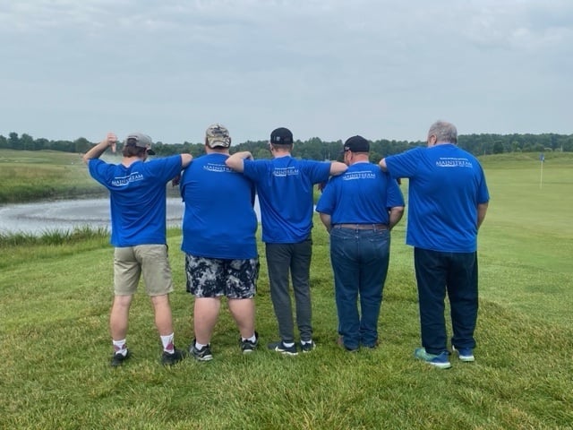 Golfers showing their shirts with Mainstream sponsorship for Blue River Services Golf Scramble